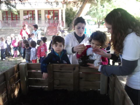 As crianças do Sonho a colocarem as minhocas no compostor para transformar os resíduos em Humus.