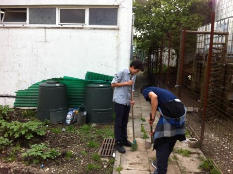 2 alunos do oitavo ano a limpar a horta . os nossos compostores