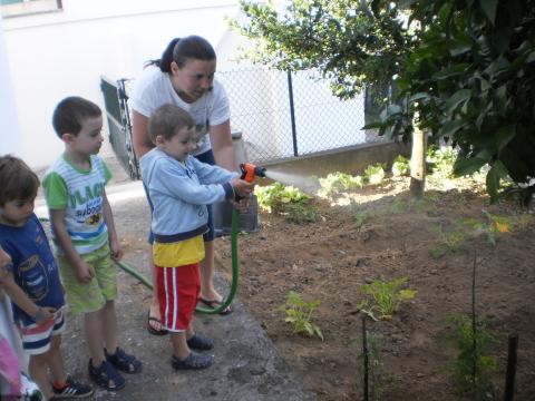 Os meninos mais pequenos precisam de alguma ajuda na rega da horta.