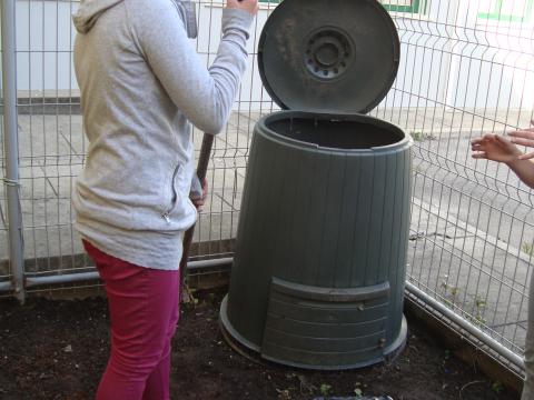 Alunos a usarem o compostor após uma breve explicação de quais os resíduos que podem ser colocados no compostor, para fazermos a compostagem doméstica dos resíduos orgânicos na horta.
