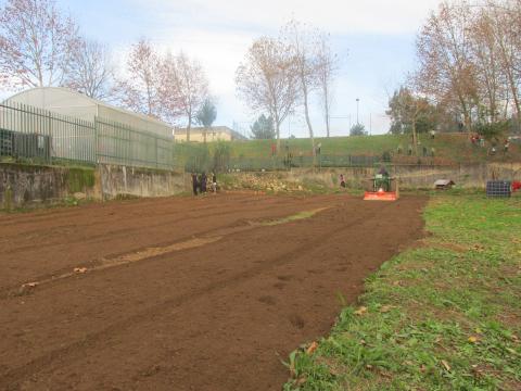 Mobilização do solo por agricultor local. Voluntários colaboram na limpeza da horta e dos espaços circundantes.
