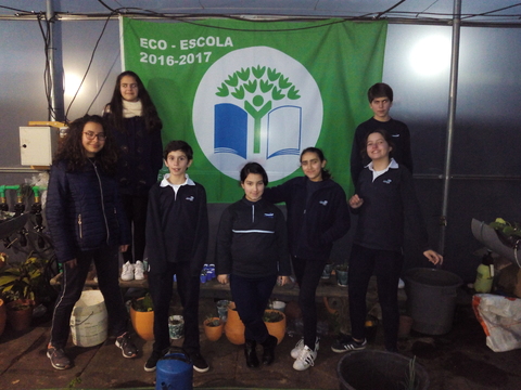 Alunos na estufa junto à Bandeira Eco-Escolas.