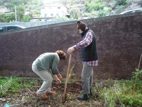 A educadora Gorete e o avô da pré, semeando favas e ervilhas.