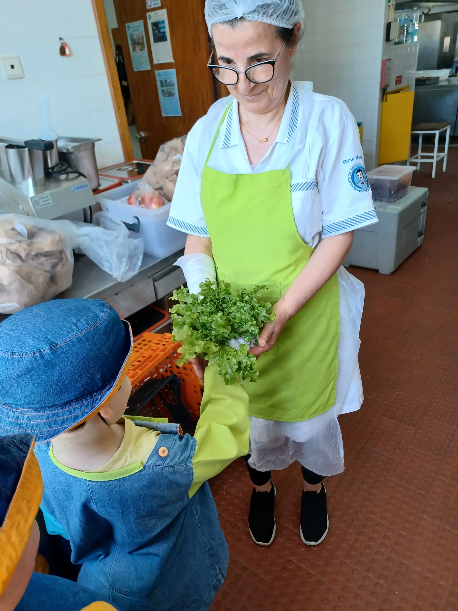 Alunos a entregar alimentos da horta no refeitório da escola