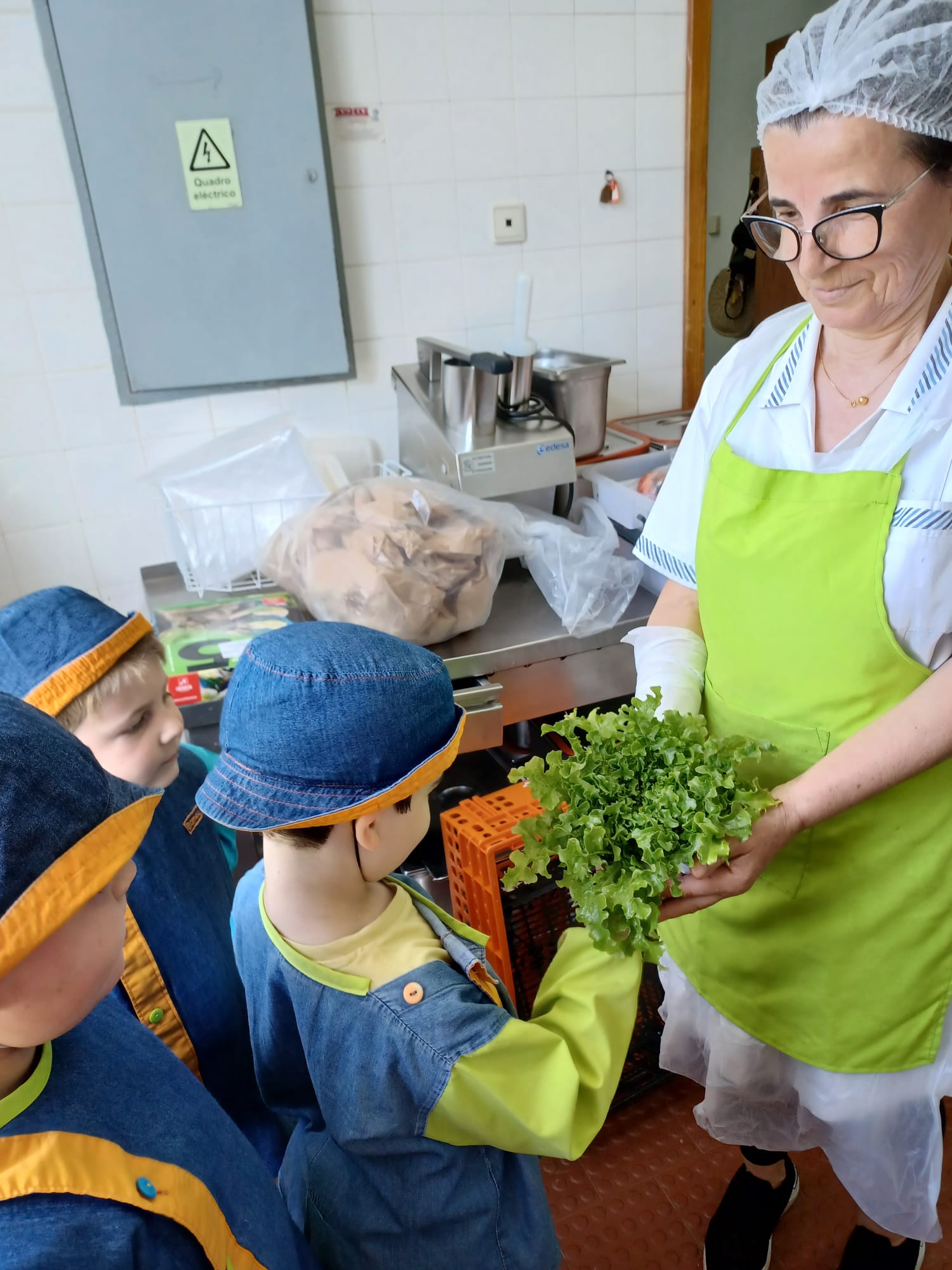 Alunos a entregar alimentos da horta no refeitório da escola