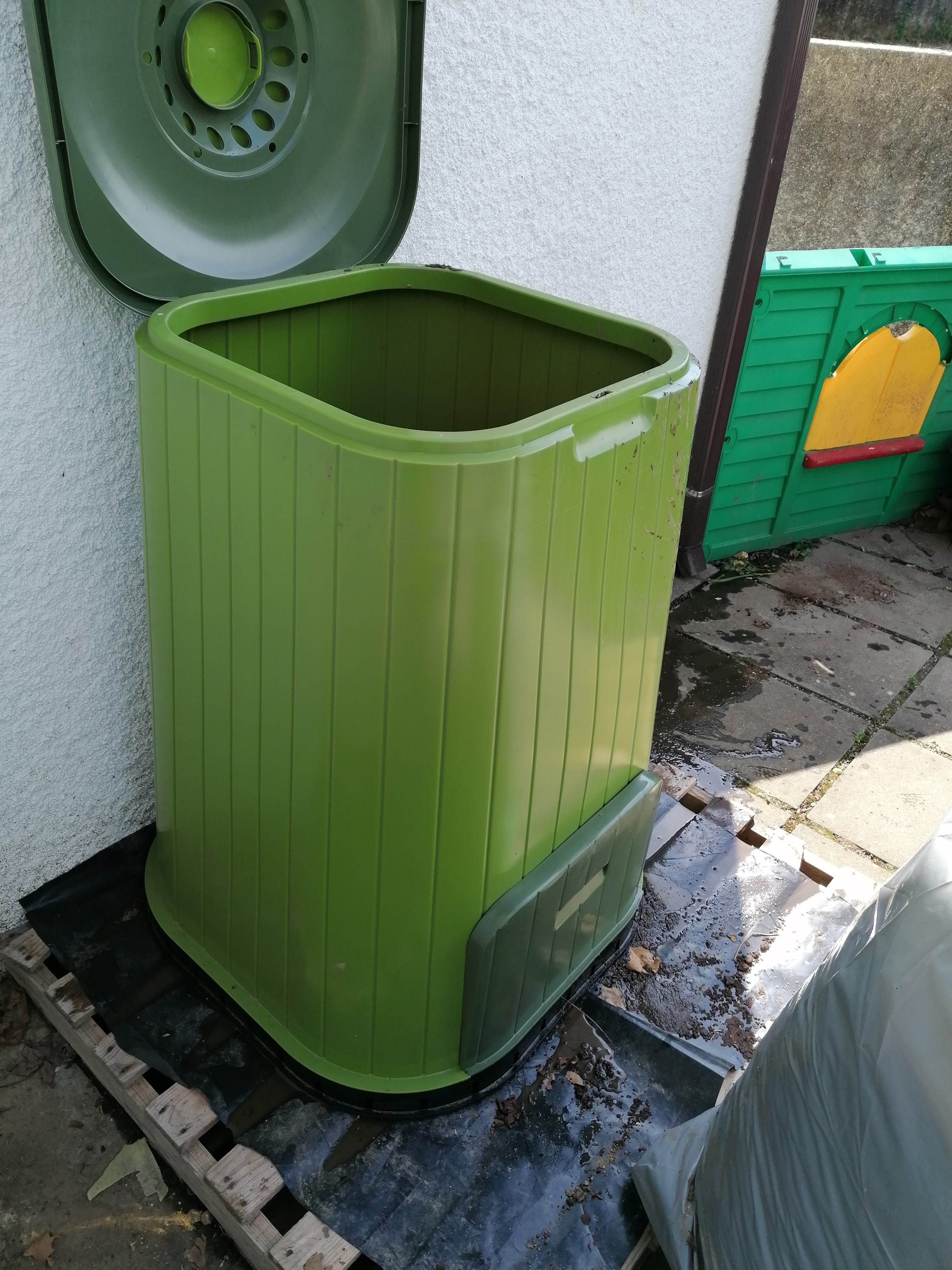 colocação do compostor no espaço da horta e colocação no seu interior do que já havia sido iniciado em saco plástico com pneus