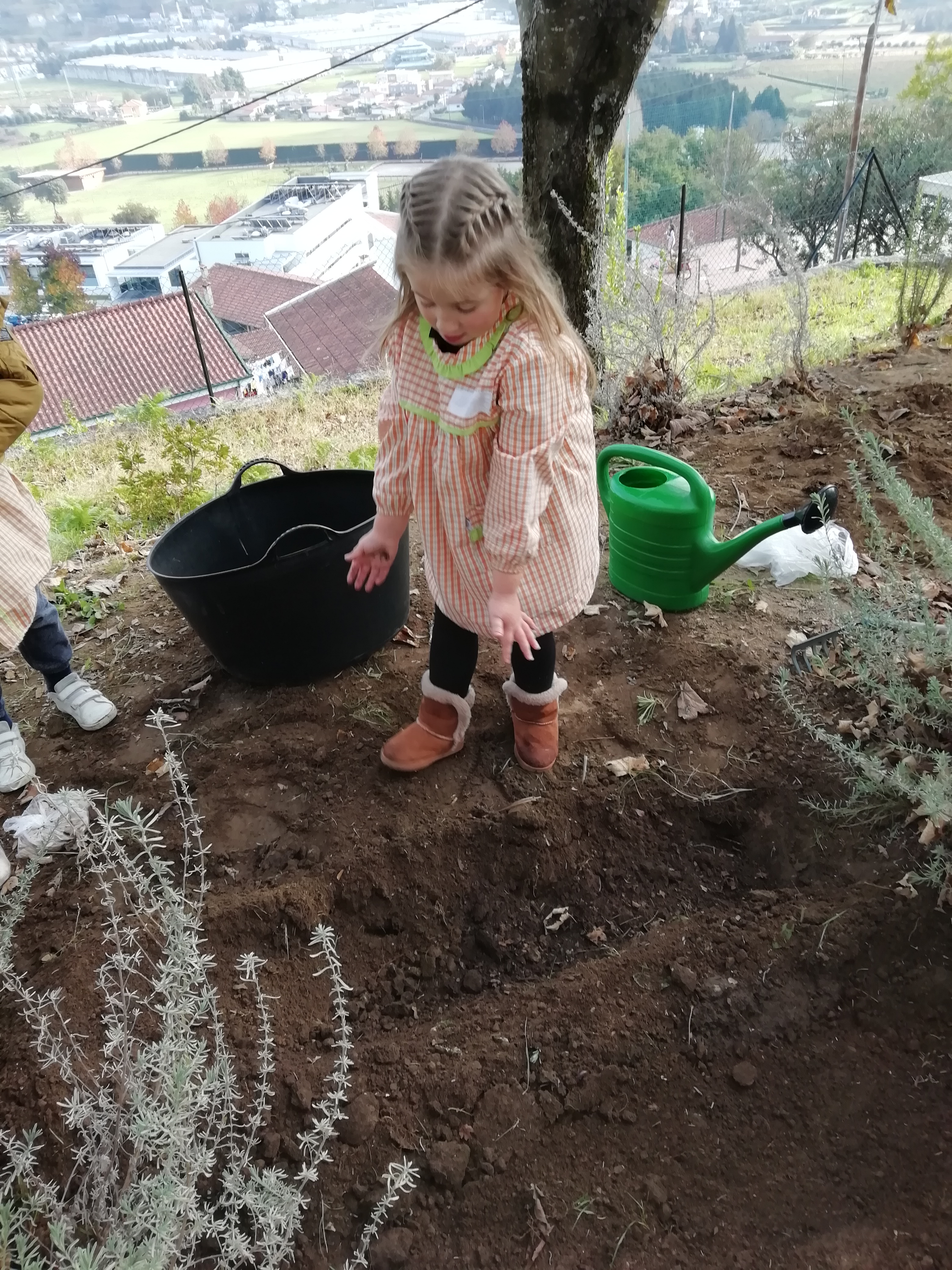 As crianças estão a colocar fertilizante retirado do nosso compostor