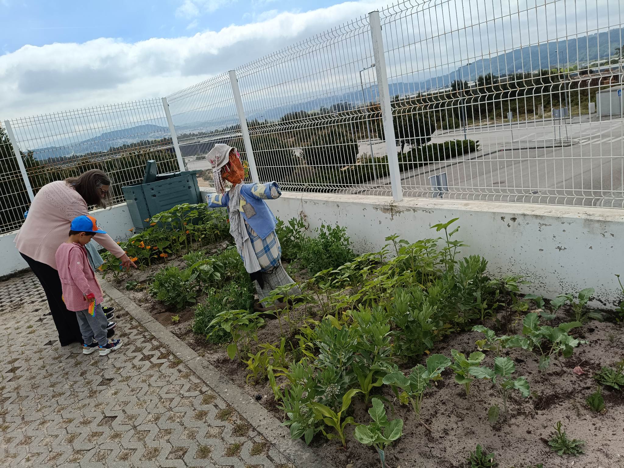 A educadora a ajudar o aluno a regar as hortícolas cada vez mais crescidas!