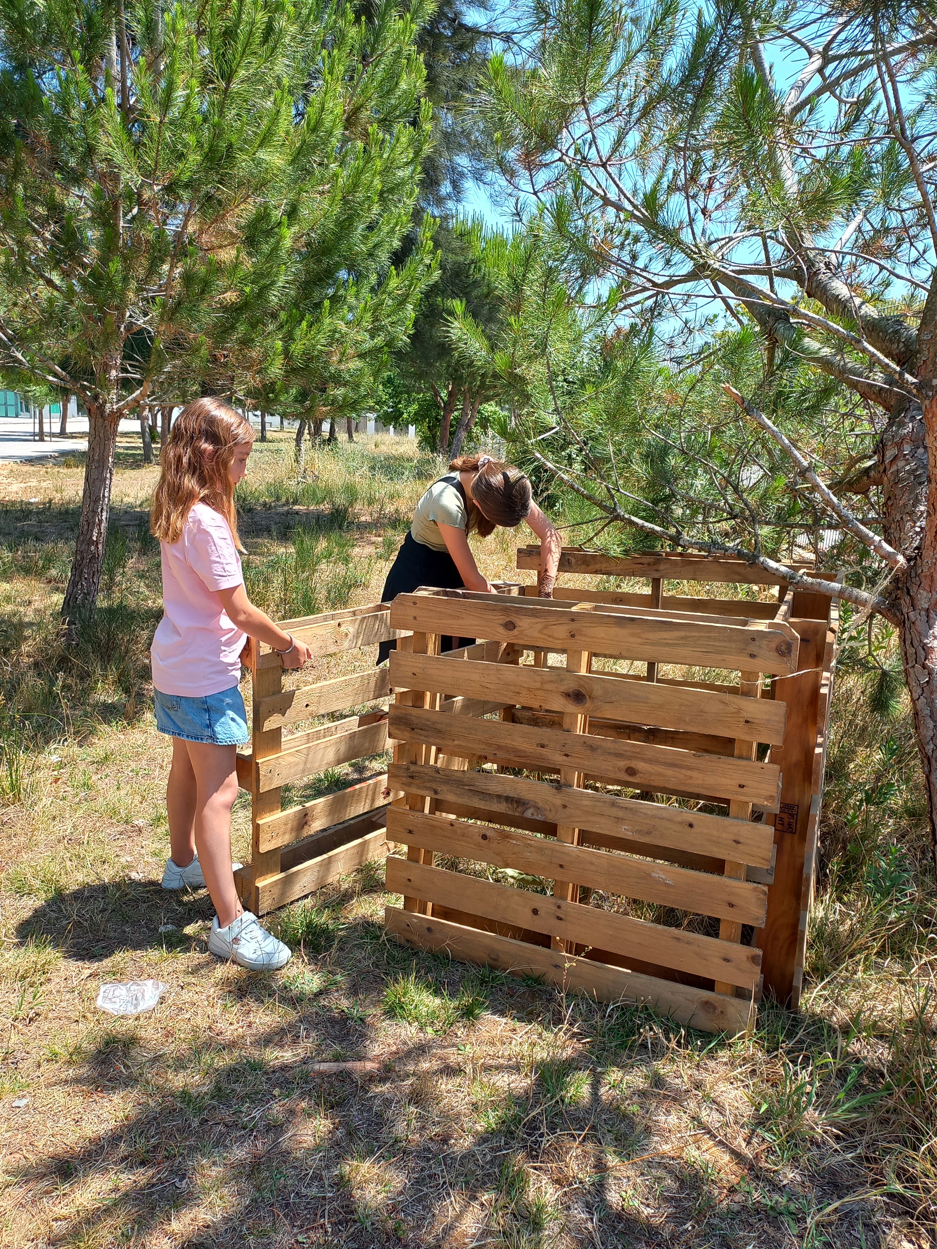 O nosso compostor foi montado com quatro paletes e é onde colocamos os restos de ervas que retiramos da horta e alguns restos de legumes da cantina e outros resíduos importantes para a compostagem.