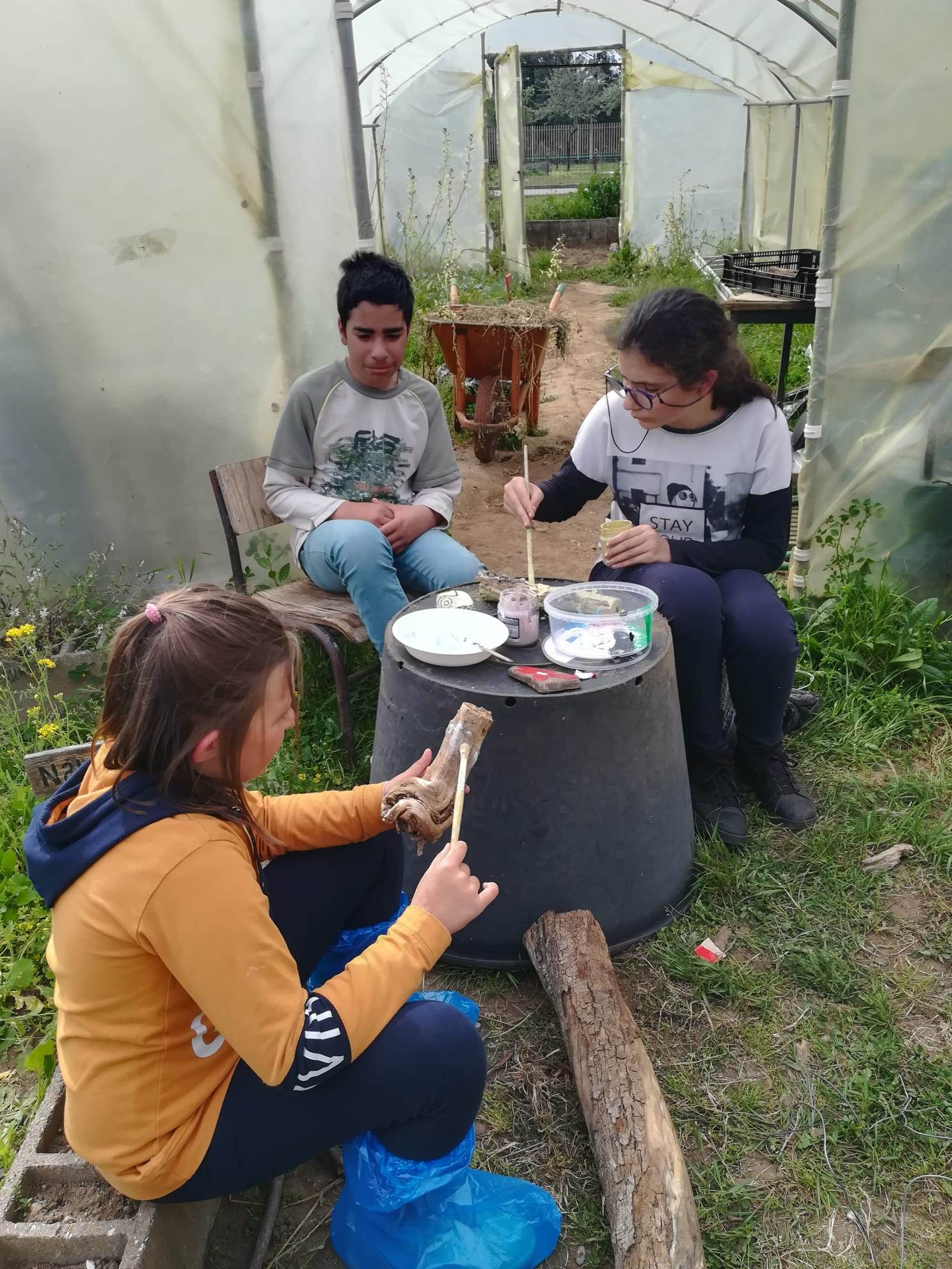 Alunos do Clube da Horta procedendo à construção de placas em madeira informativas dos produtos biológicos plantados e pintados, bem como à construção de figuras alusivas a animais da horta, pintados em pedras.