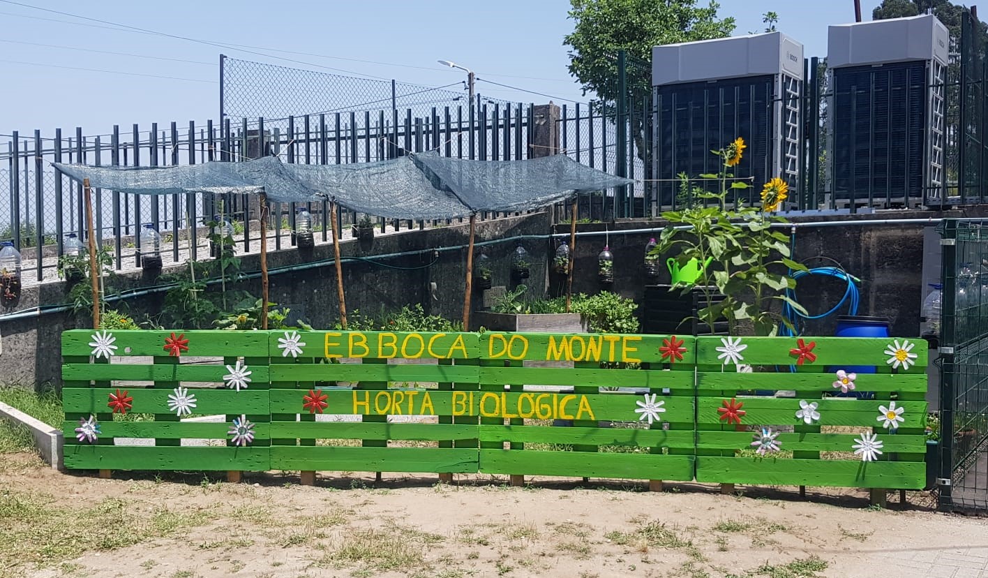 A cerca da horta está pronta! Depois de pintada, escrevemos o nome da nossa escola e fizemos flores de copos de iogurte para a decorar.