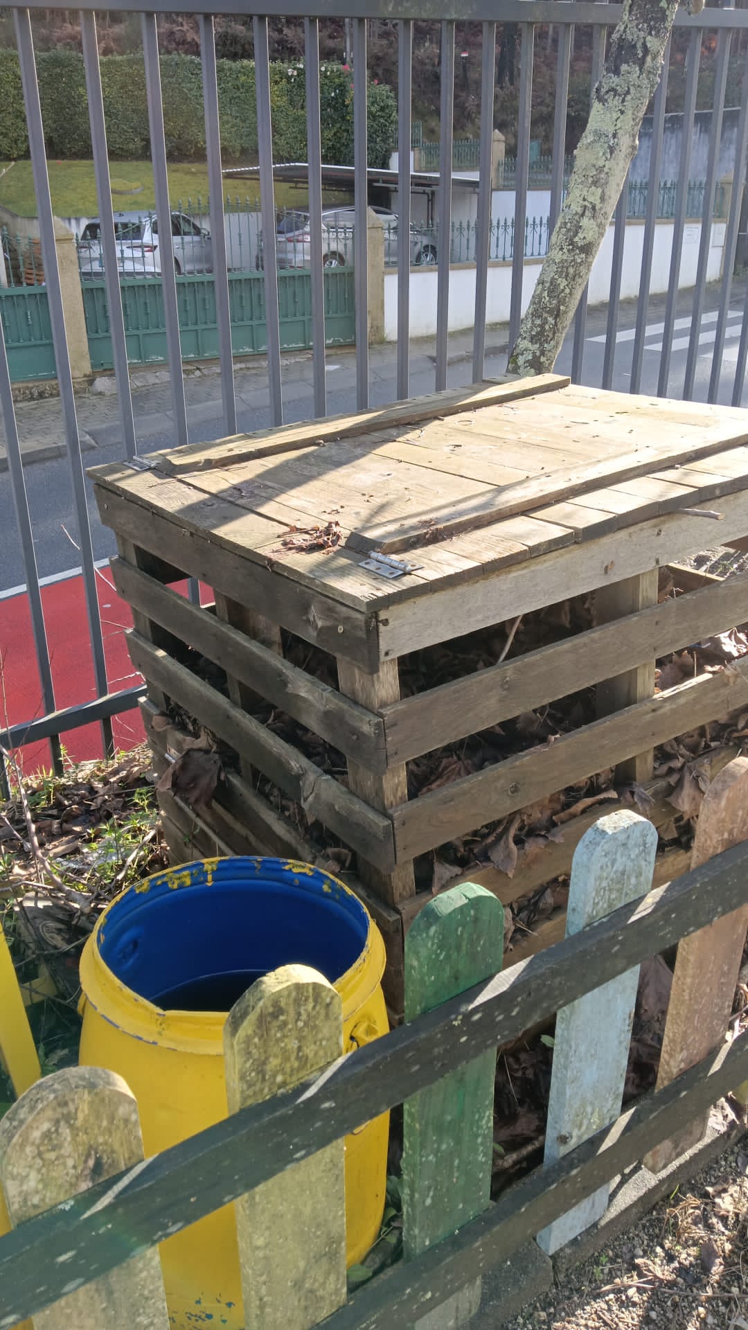 Compostor e recipientes de recolha da água da chuva para rega.