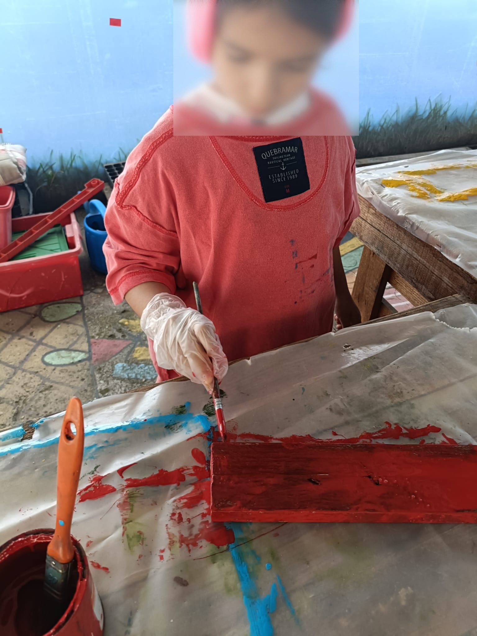 Criança a pintar as placas