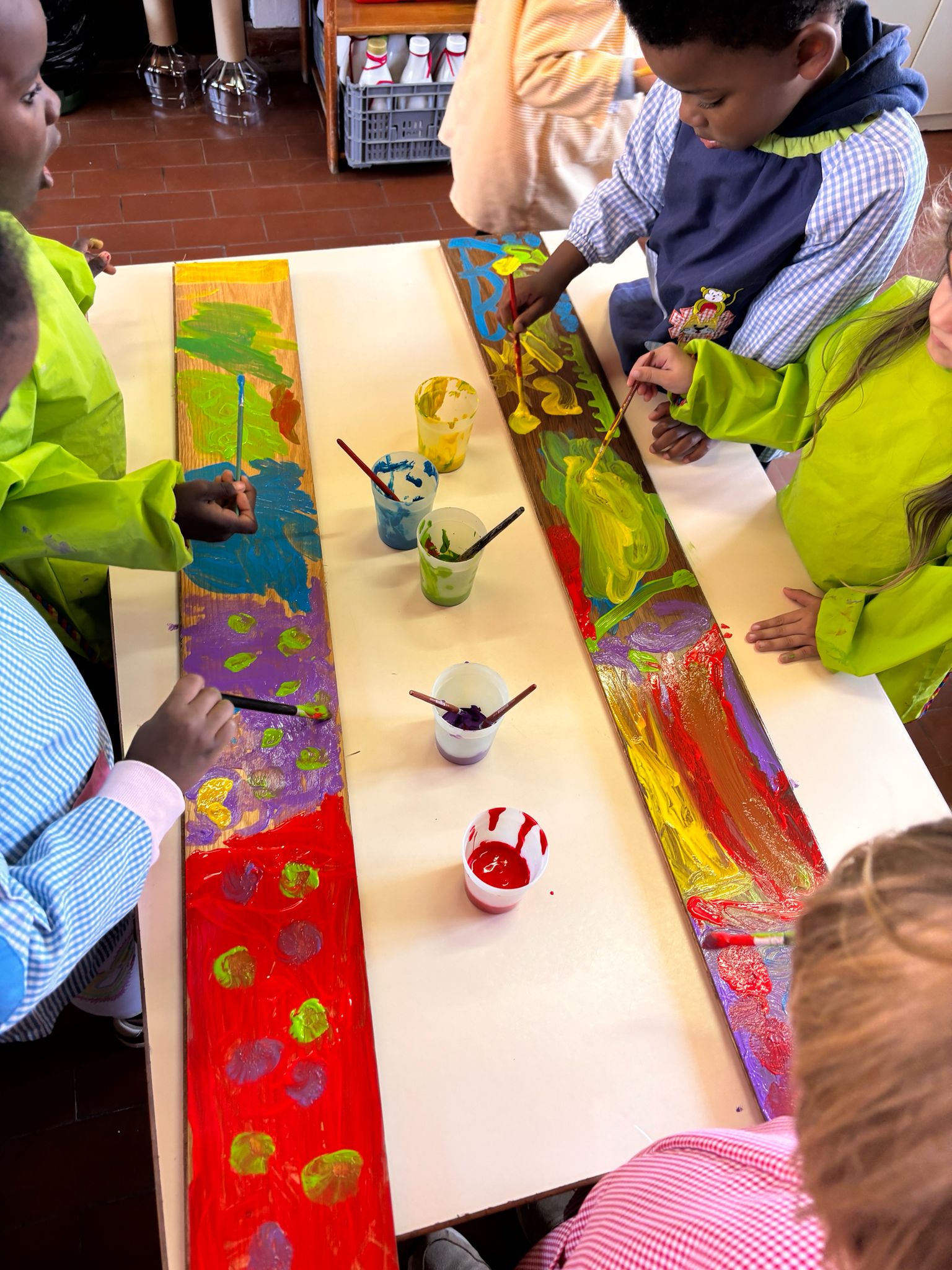 Pintura: As crianças pintaram as tábuas com cores e formas criativas.