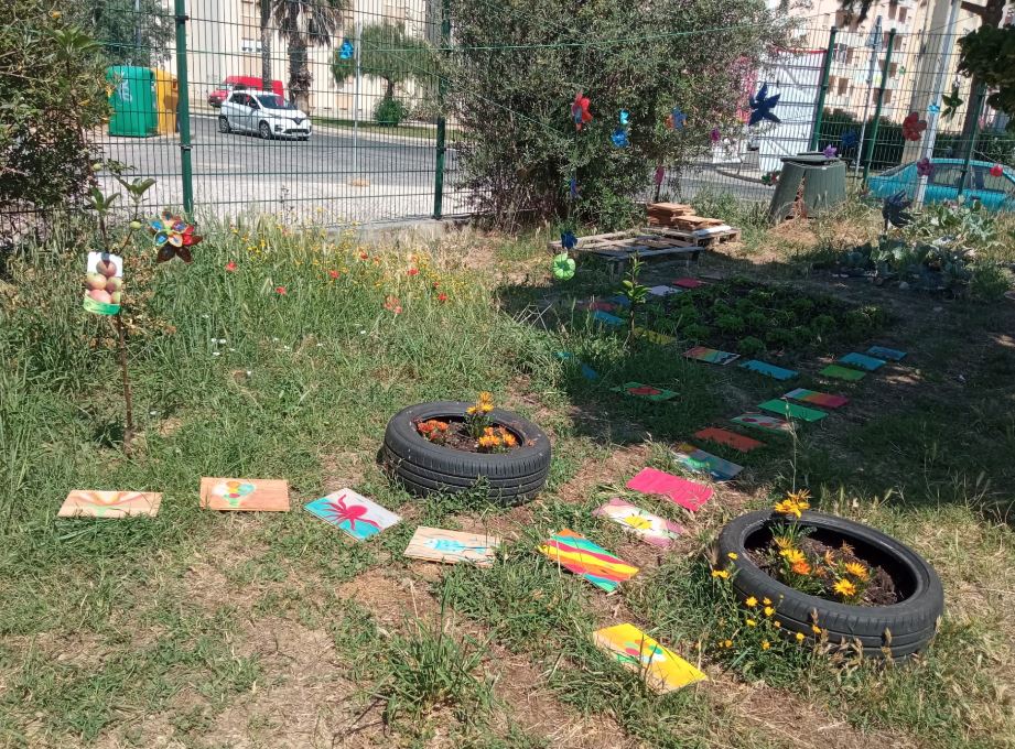 Entrada na horta, com painéis de madeira pintados pelos alunos dispostos no caminho.