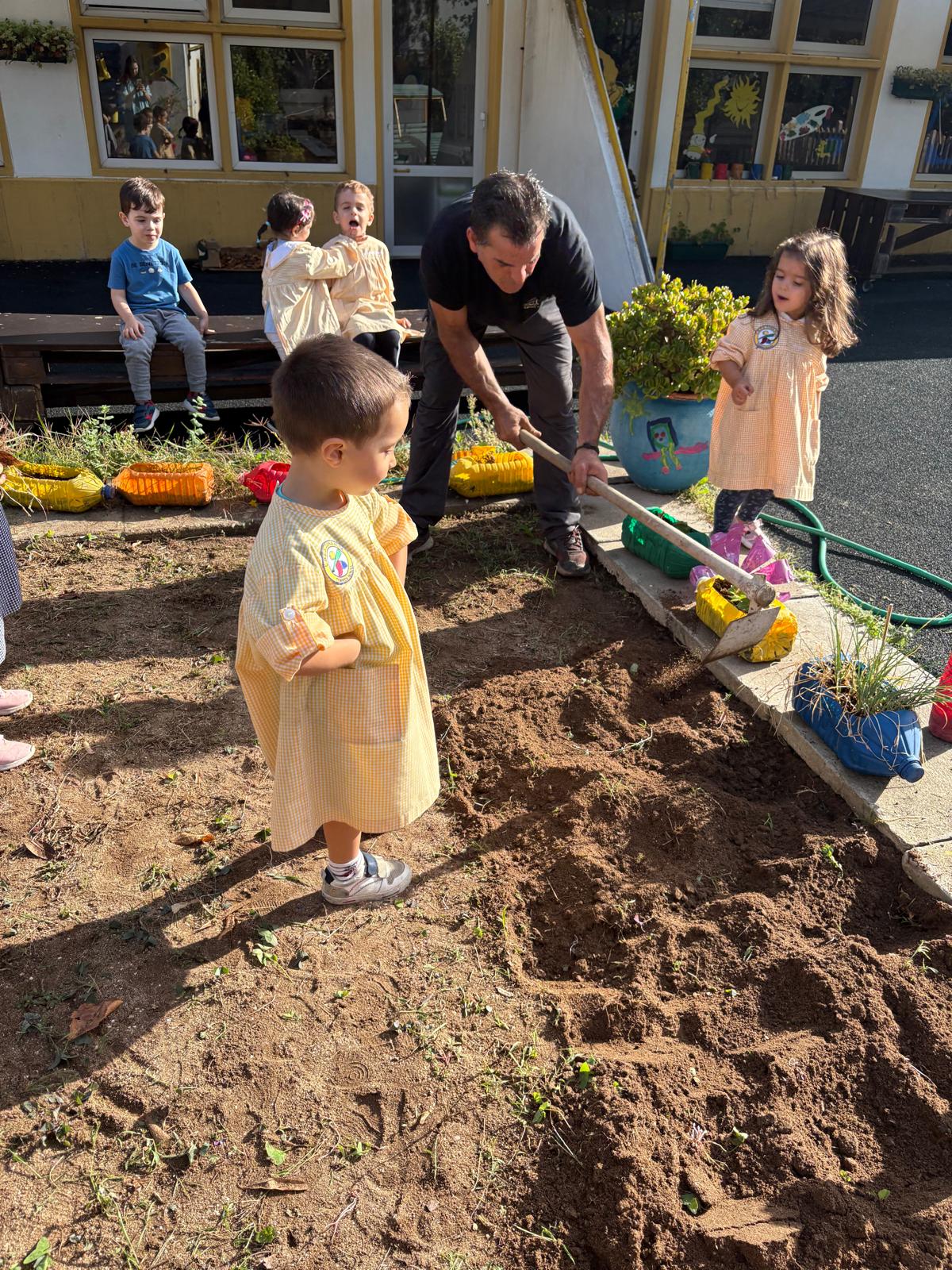 Com a ajuda de um dos pais da sala, começamos a preparar a terra para receber as sementes.