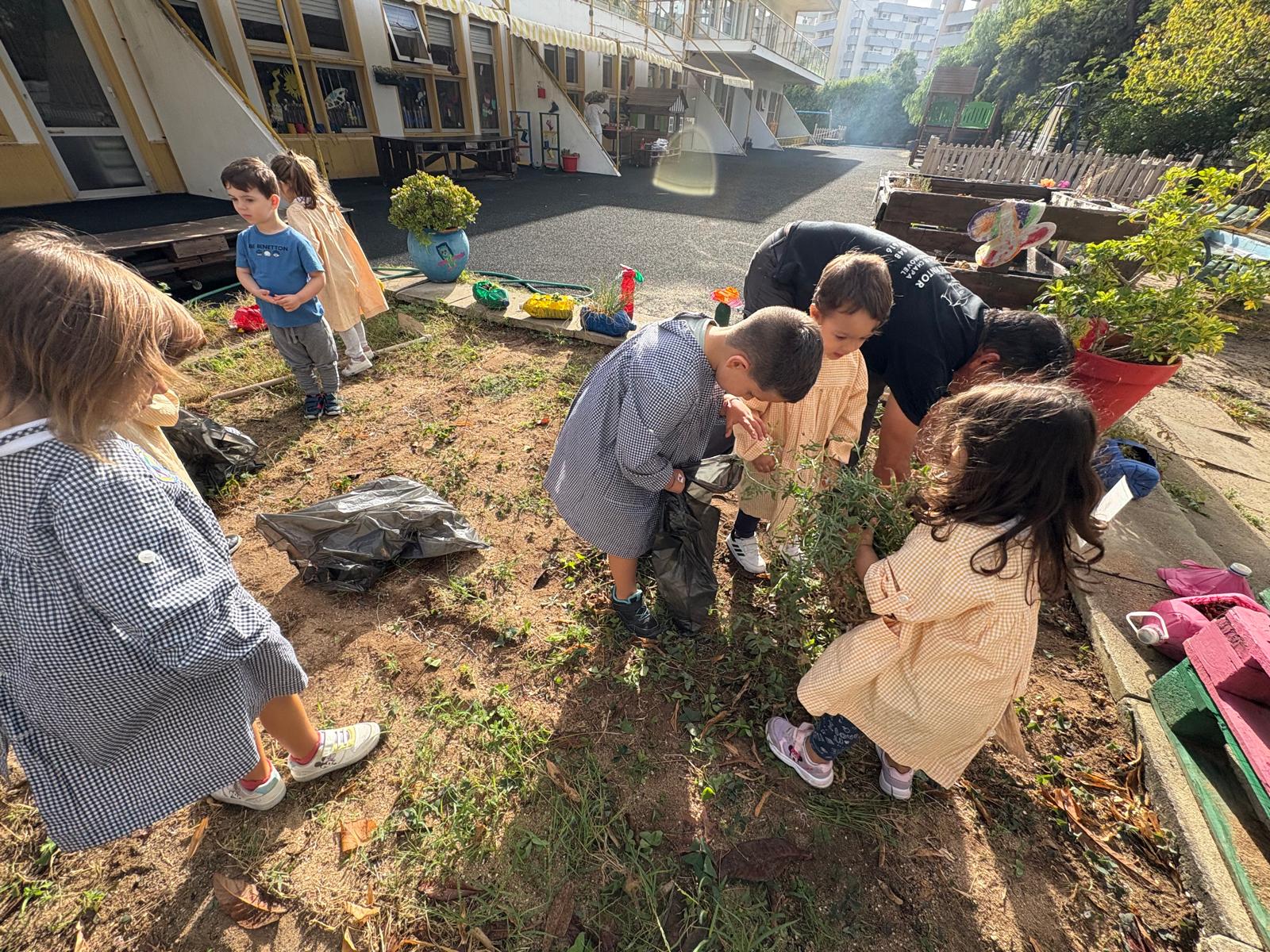 O grupo de crianças foi arrancando as ervas daninhas, colocando-as num saco.