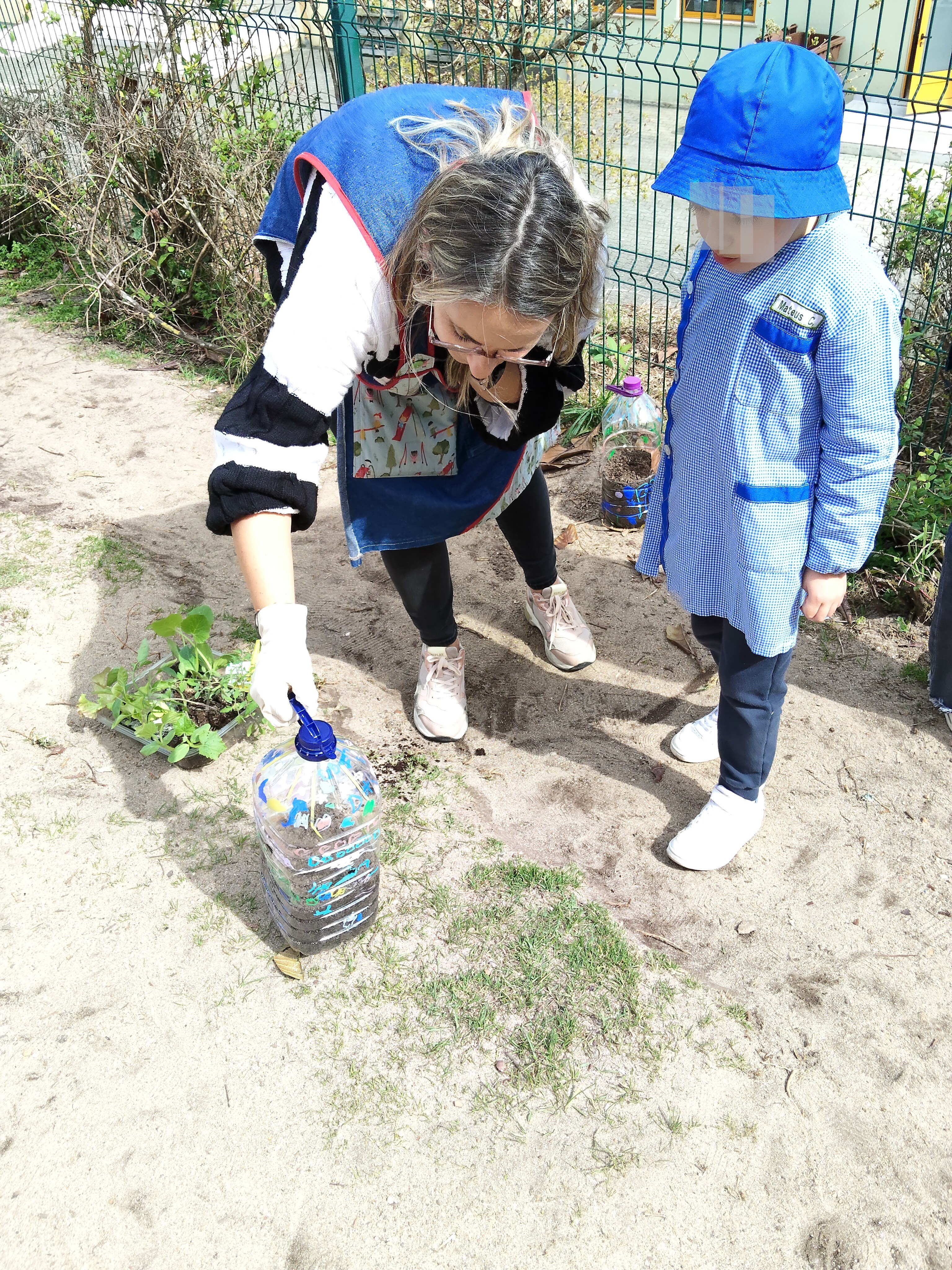 Enquanto esperamos os senhores da Junta de Freguesia para manutenção do terreno da horta, resolvemos fazer uns canteiros, aproveitando garrafões de água vazios que os pais foram trazendo.