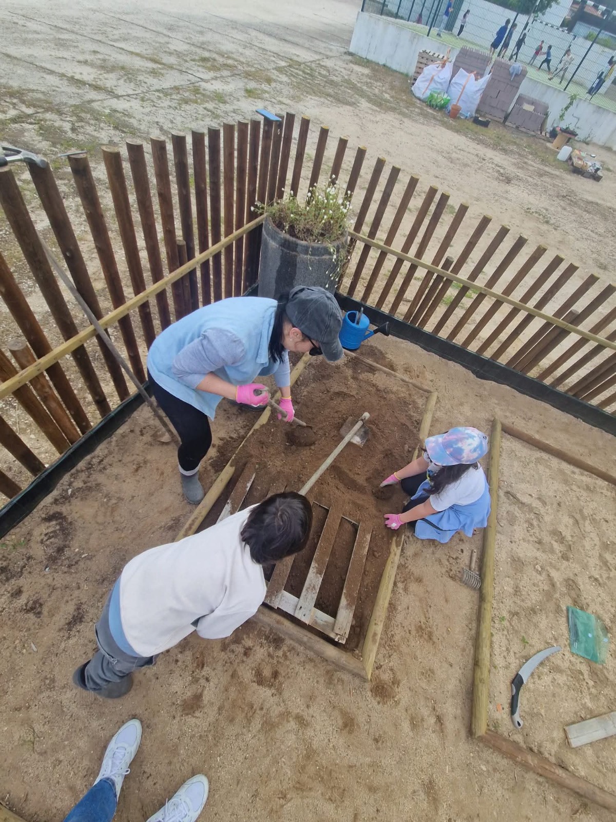 Crianças e pais tutores envolvidos na preparação de um canteiro da Horta Feliz, através da mobilização da terra e organização do espaço. Esta etapa reforçou o trabalho em equipa e marcou o início das atividades práticas na nossa horta.
