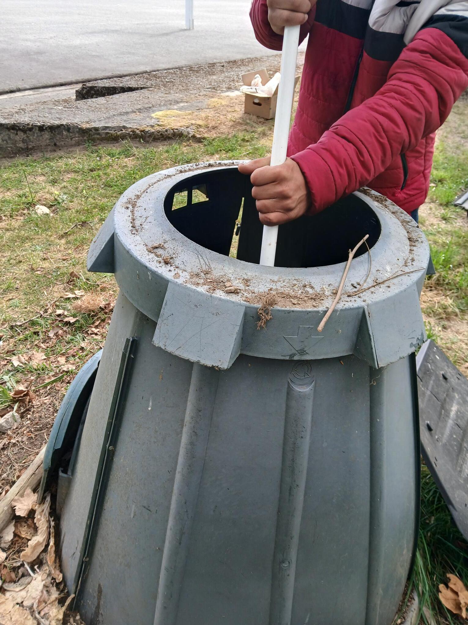 Os alunos realização a adição de resíduos no compostor