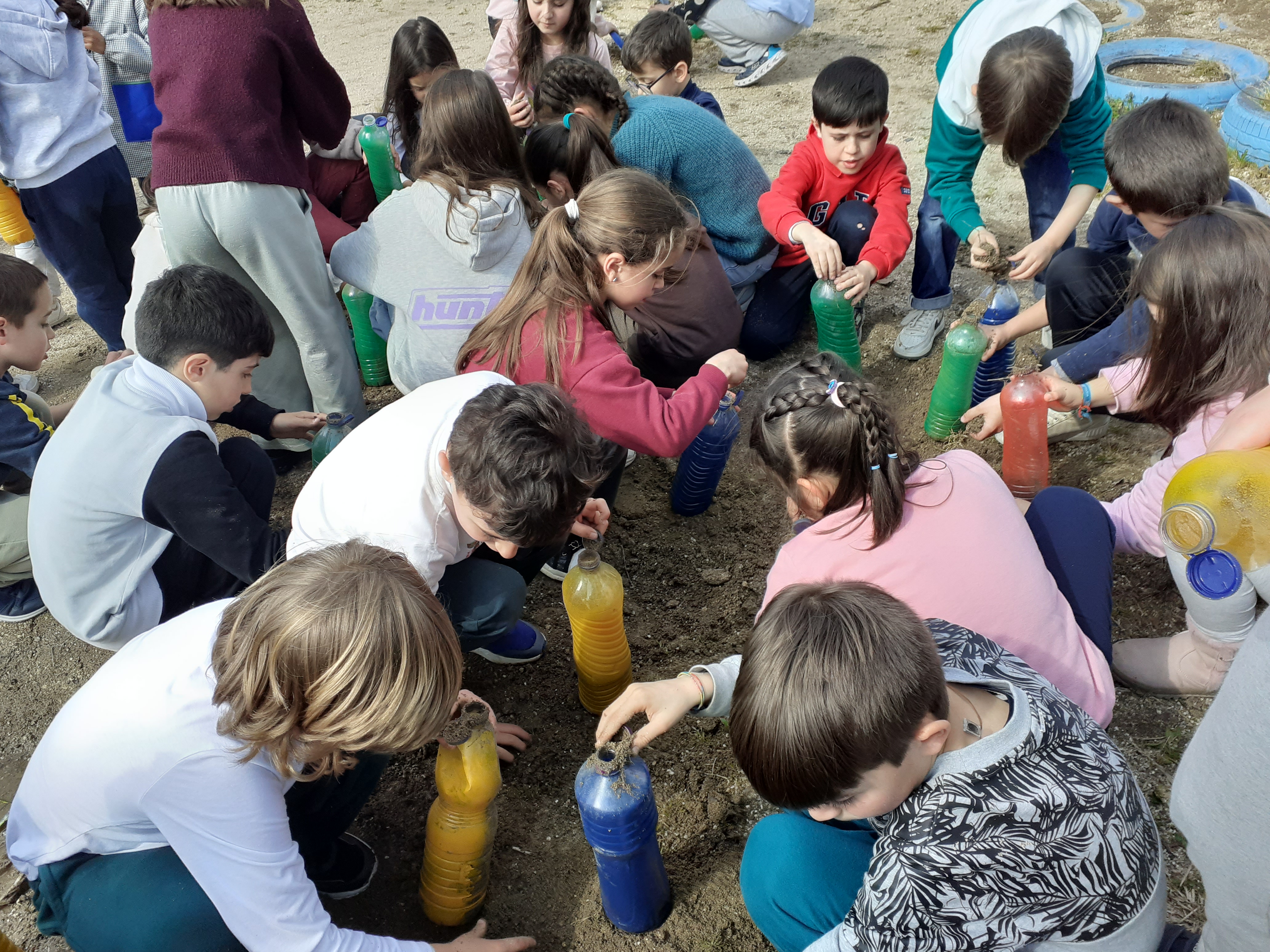 Atividade levada a efeito por todas as crianças da escola, com o intuito de encherem as garrafas com areia existente no recreio para construir a vedação da horta.