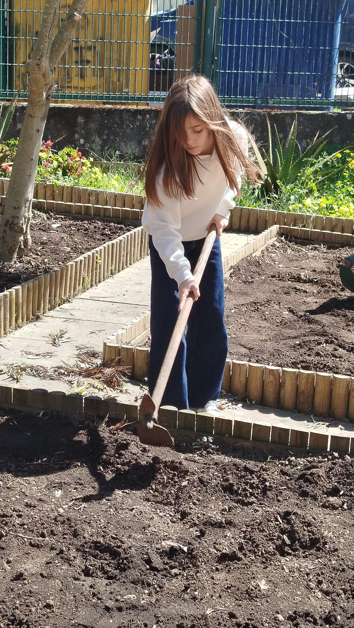Aluna a preparar a terra para as plantações.